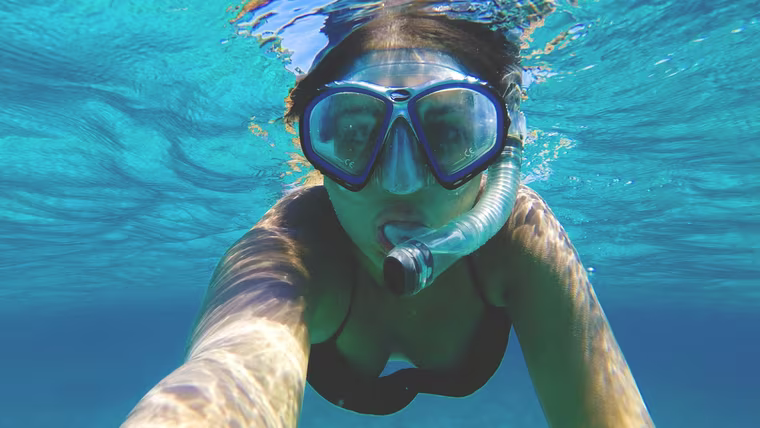 A snorkeller underwater in clear blue sea off Phuket